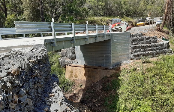 Image Gabion baskets are stacked either side of a bridge under construction