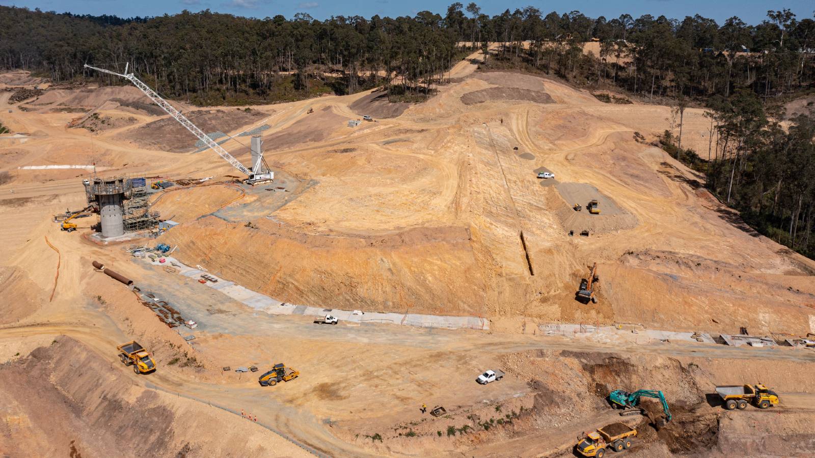 Large scale earthworks are underway with forest in the background.