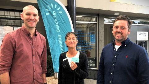 Two men and a woman standing in a shopping mall