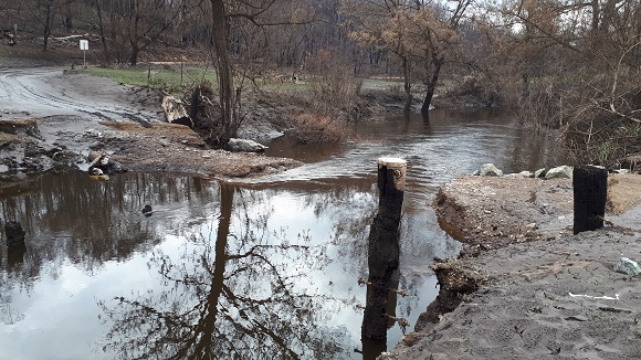 Image Flood waters wash away the temporary track across the creek