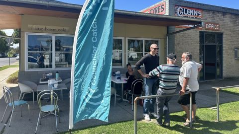 a group of people around an outside table