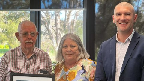 two men and one woman smiling