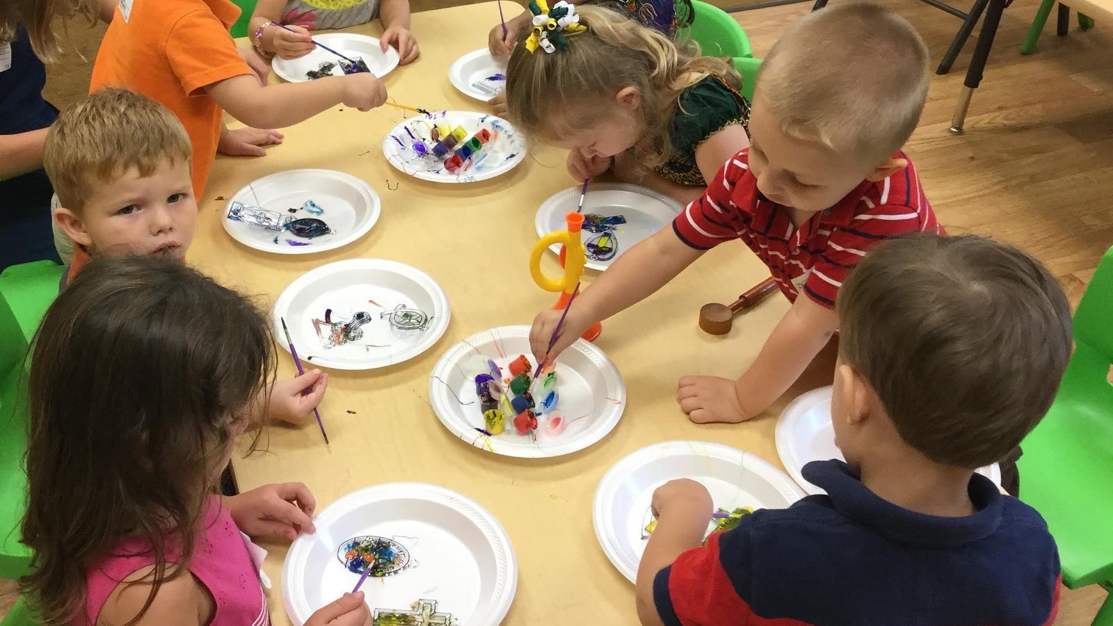 Preschool kids sitting on a table together doing craft banner image