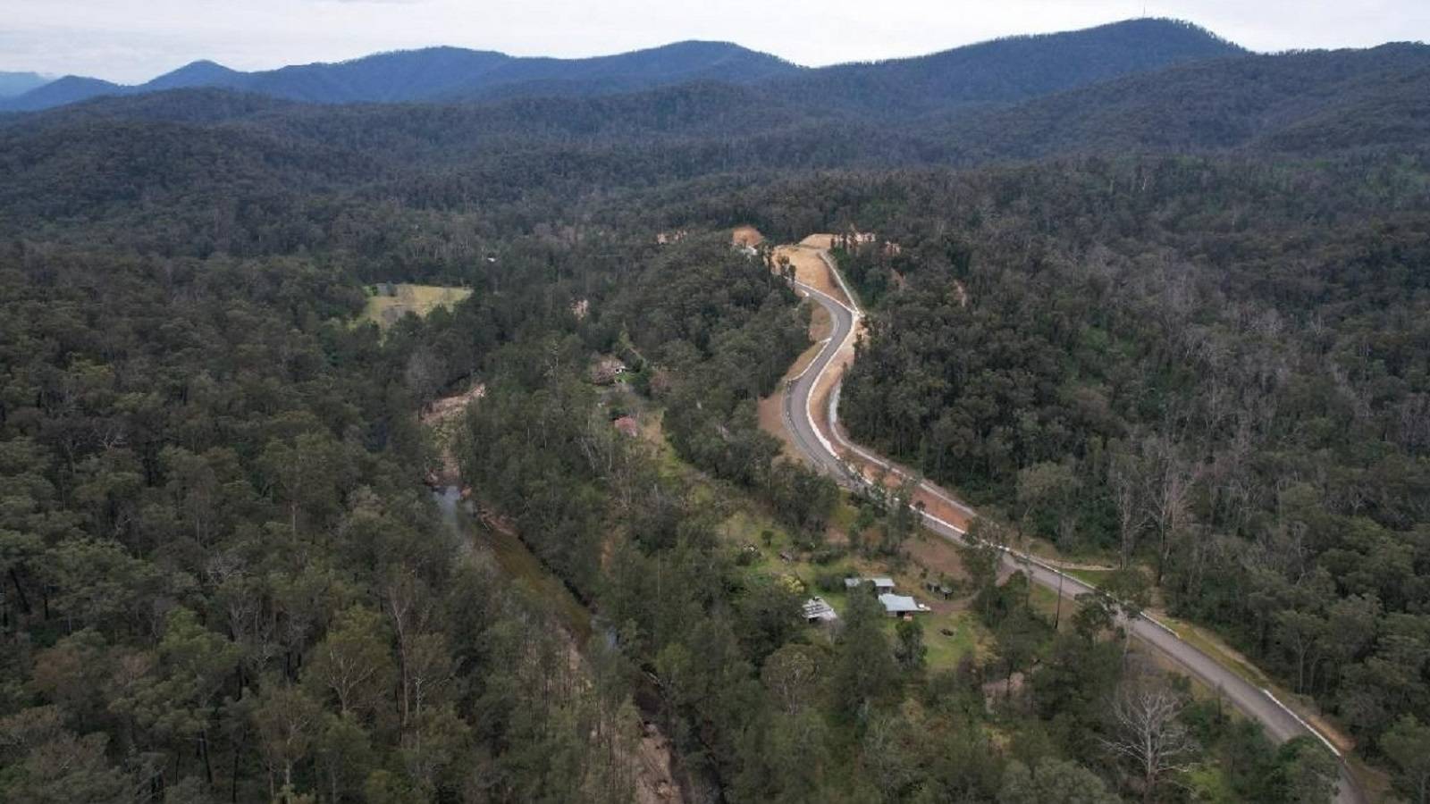 A new sealed road meanders though forested mountains.