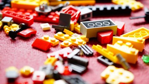 Brightly coloured LEGO pieces scattered on a pink mat.
