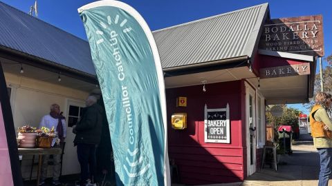 councillor catch up promotional flag outside a bakery 