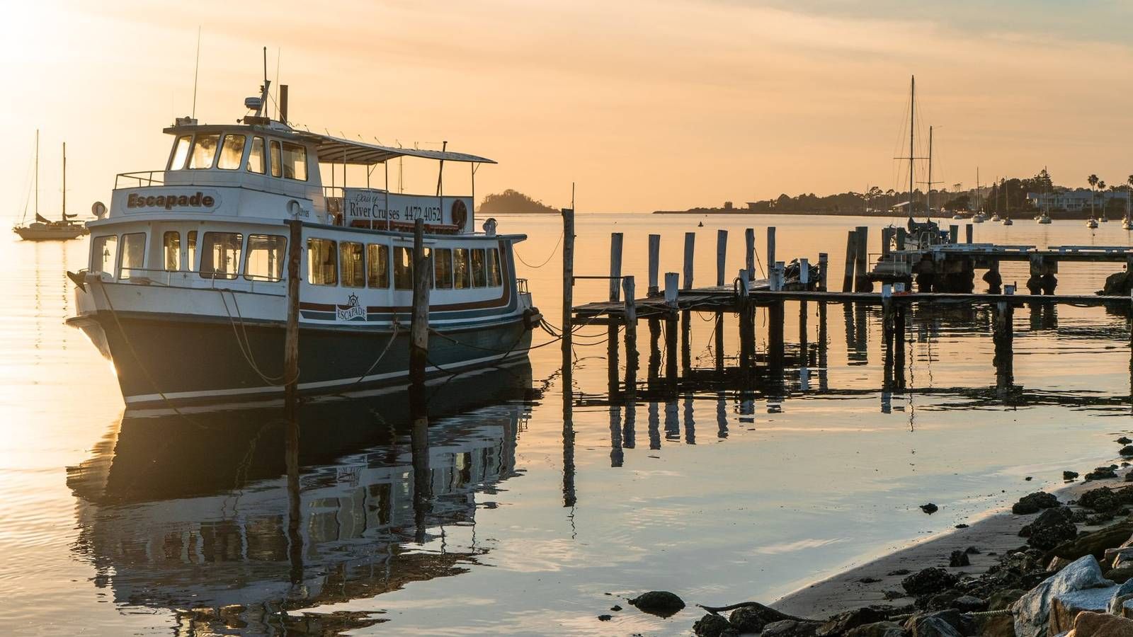 Cruise boat docked at the wharf with sunset in the background banner image