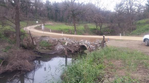 Image a piped culvert sits in the creek with a road above