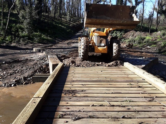 Image A loader works to restore access across atimber bridge