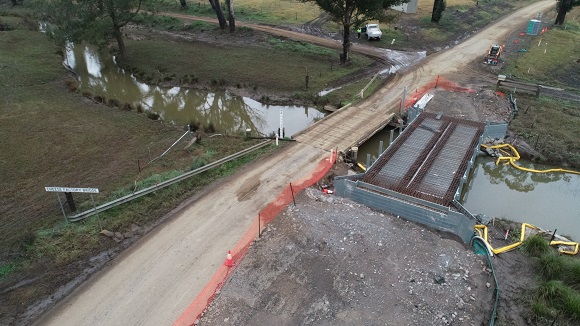 A drone photo shows a new bridge under construction alongside the sold timber bridge