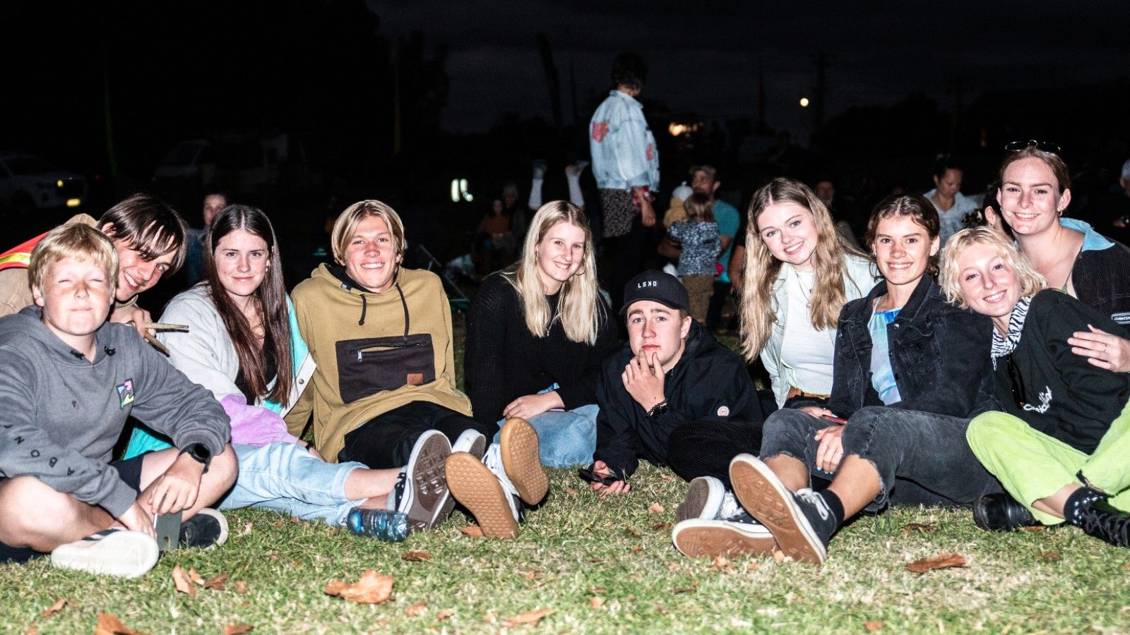 Photo of young people sitting on grass. banner image