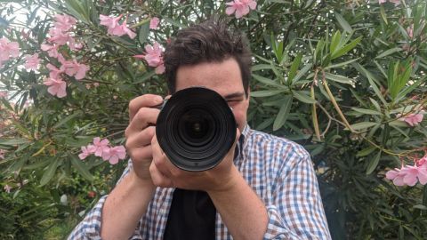 Young man looking through a camera.