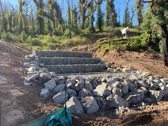 Image Rows of gabion baskets and rocks are stepped up a steep slope