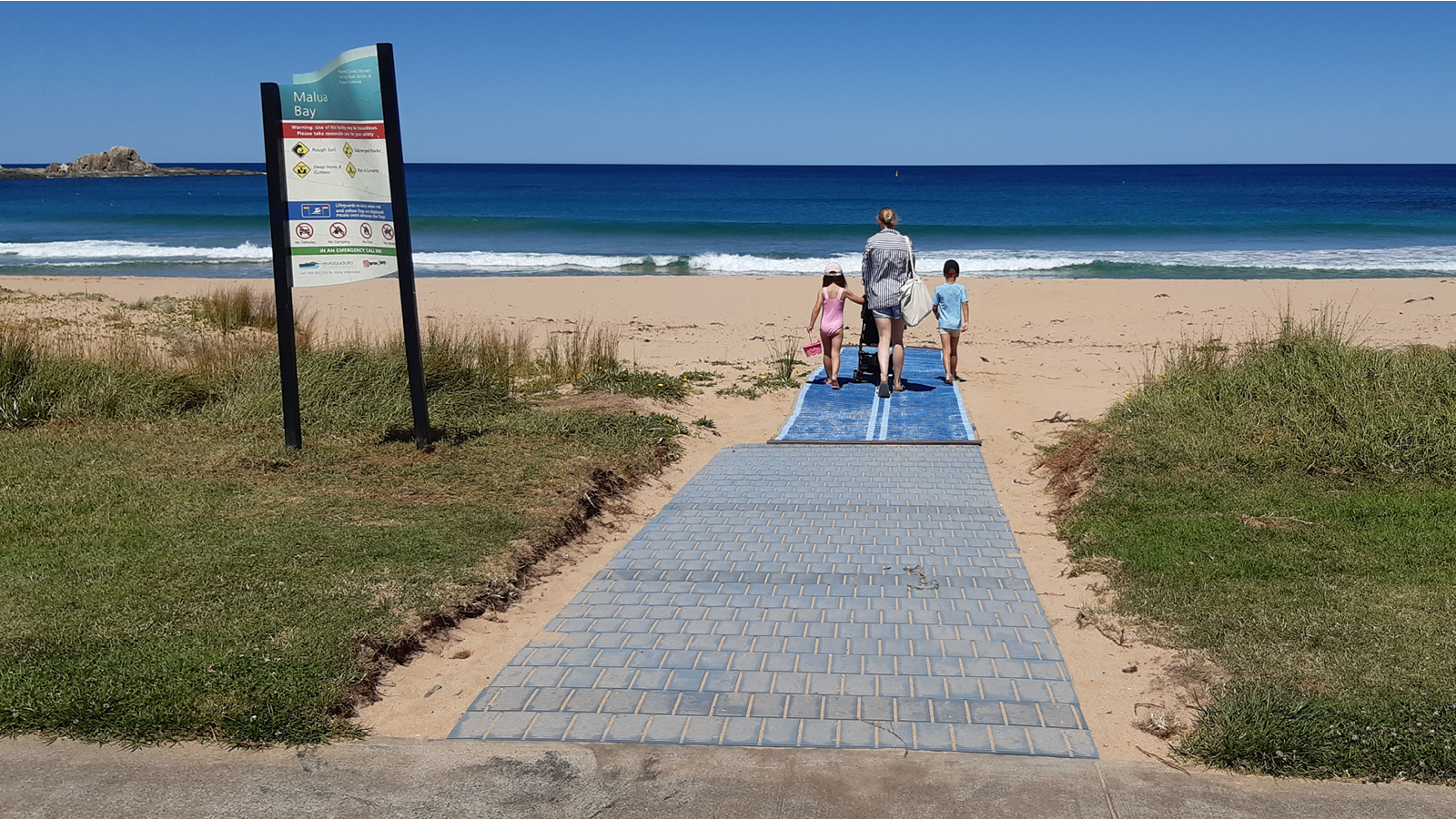 Image Photo of lady with pram and two children walking on mobility mat.