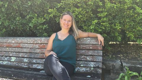 Woman sitting on a chair in front of a tree