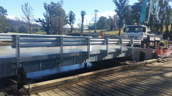 Image A new aluminium and concrete bridge sits higher than the old bridge