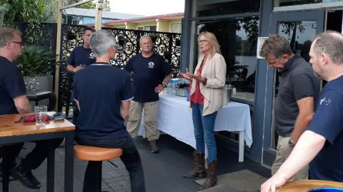 A group of people talk in a social setting.