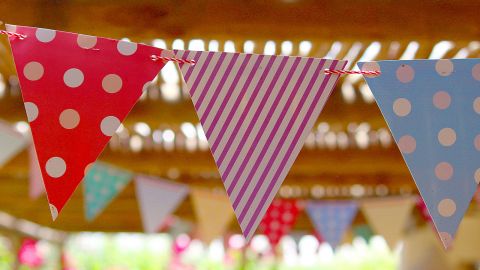 Colourful party bunting flags hanging from a ceiling.