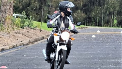 Lady riding motorbike in carpark
