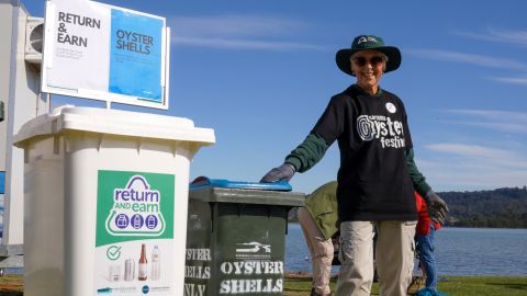 Woman standing next to bins