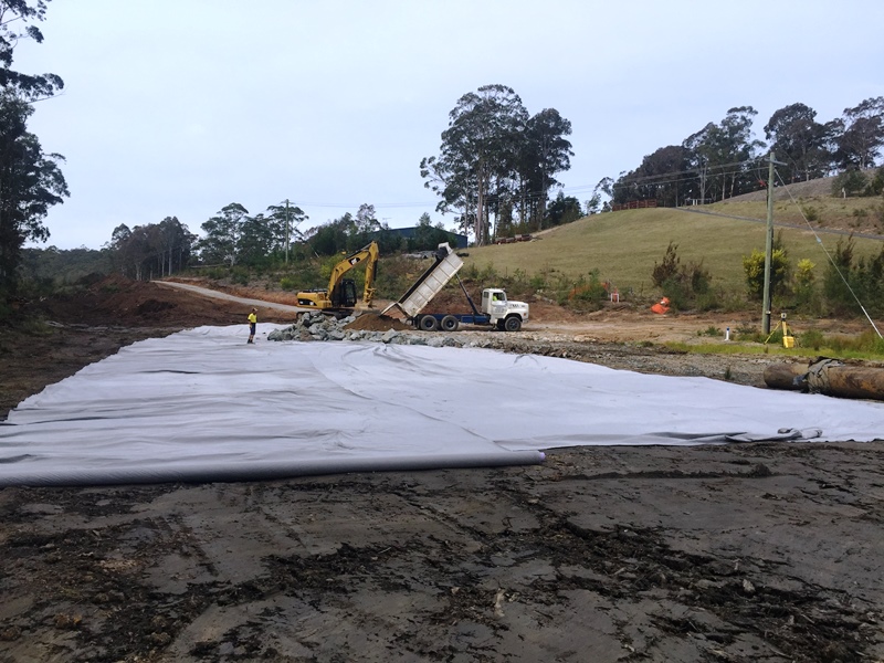 Image After the topsoil is removed, geofabric is spread to form the first layer.