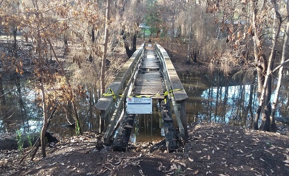 Image Deck timbers on the footbridge have been burnt and a sign warns the bridge is closed