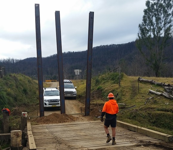 Image Three steel piles stand tall at the end of the bridge