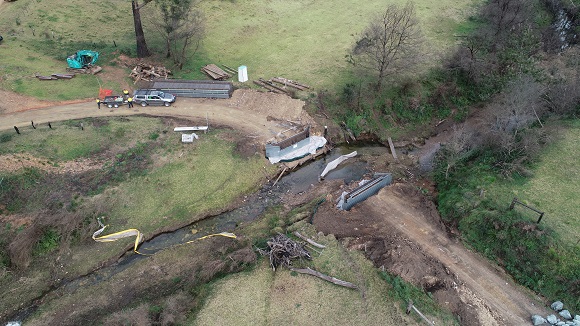 A drone photo shows construction on both sides of the creek