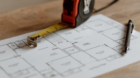  Plans of a house with tape measure on top.