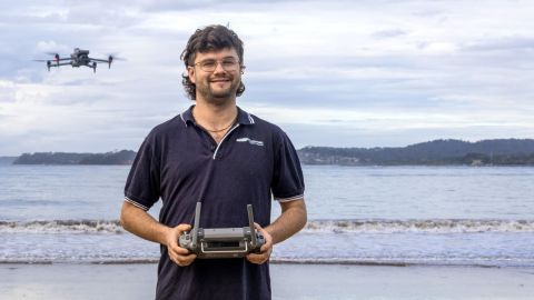 A man standing with a drone in the air